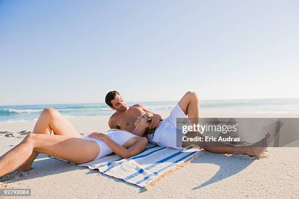 couple lying on the beach - pechos de mujer playa fotografías e imágenes de stock