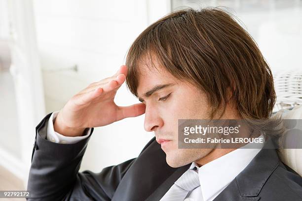 close-up of a man suffering from a headache - sad groom stock pictures, royalty-free photos & images