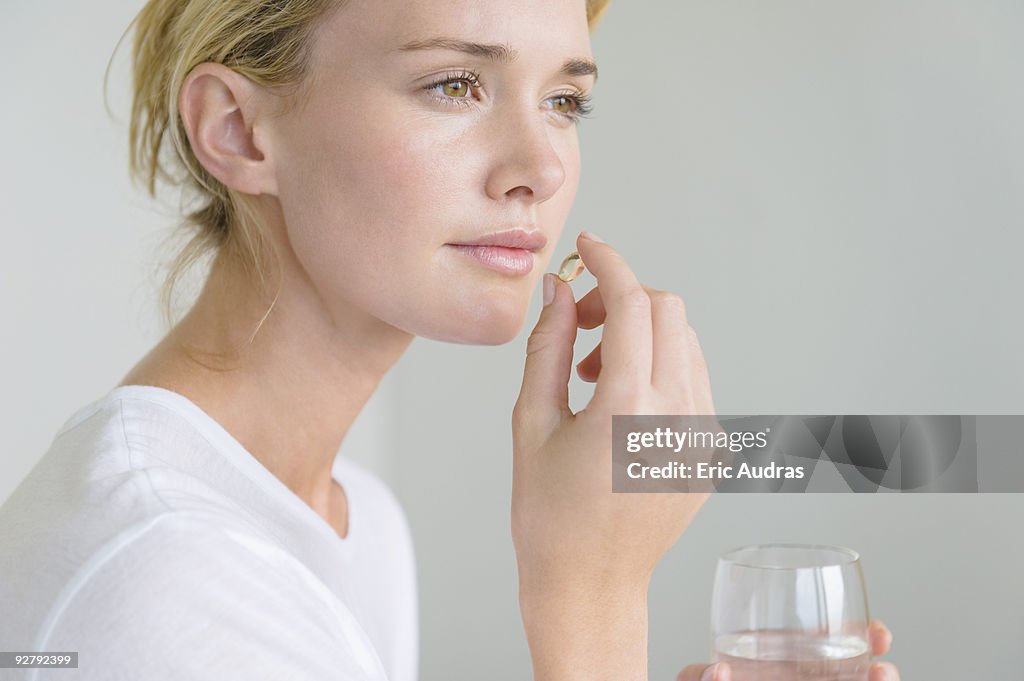 Woman taking an Omega-3 capsule