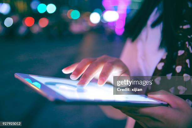mano con tableta digital en la noche - pantalla plasma fotografías e imágenes de stock