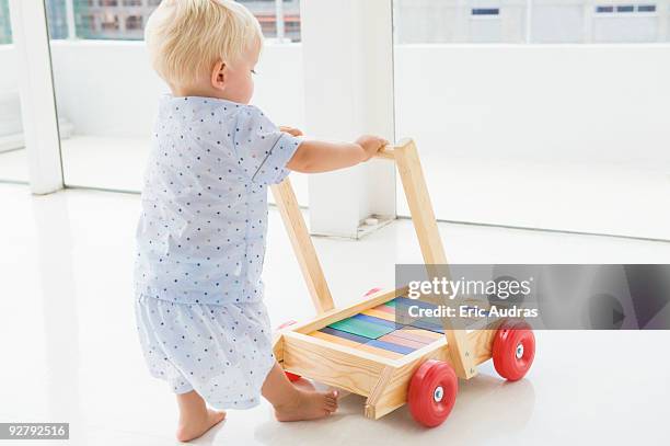 baby boy pushing a cart - chariot wheel photos et images de collection