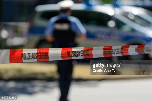 police cordon with barrier tape, at back patrol cars and police officers, frankfurt am main, germany - police and criminal imagens e fotografias de stock
