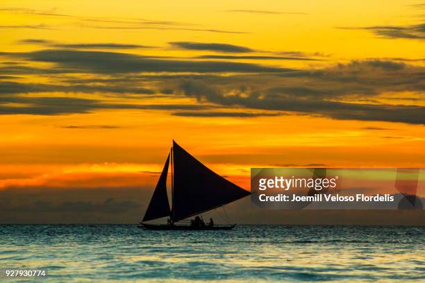 a sailing paraw/double outrigger at sunset (boracay island, malay, aklan, philippines) - joemill flordelis stock pictures, royalty-free photos & images