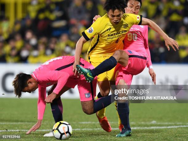 Kashiwa Reysol's defender Shinnosuke Nakatani is sandwiched by Kitchee defenders Li Ngai Hoi and Kim Bong-Jin during the AFC Champions League...