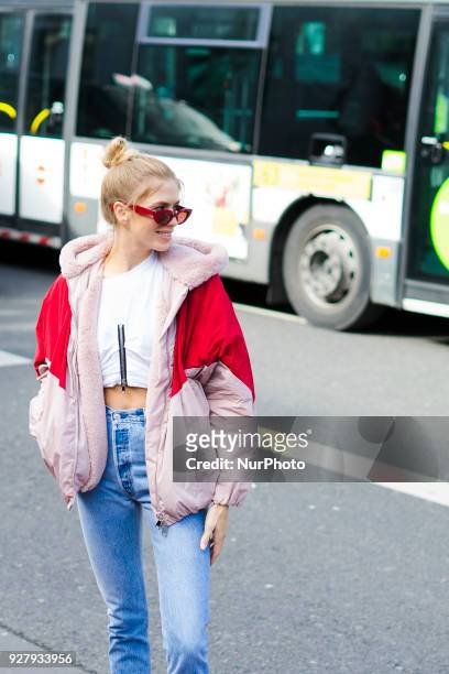 Lena Perminova wears a red and pink bomber jacket, cropped jeans, white shoes, sunglasses, outside Giambattista Valli, during Paris Fashion Week...