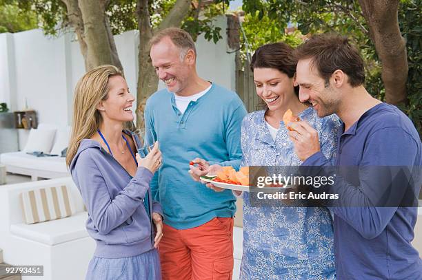 four friends eating fruits and having fun - four people foto e immagini stock