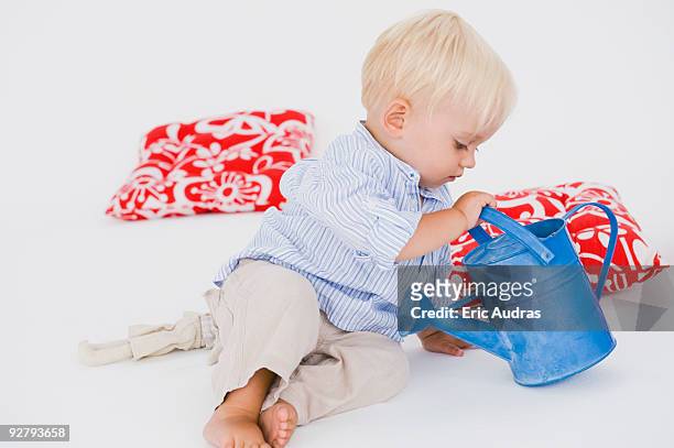 baby boy playing with a watering can - arrosoir fond blanc photos et images de collection