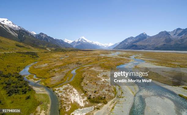 wide riverbed of tasman river, mount cook at back, mount cook national park, canterbury region, south island, new zealand - canterbury region new zealand stockfoto's en -beelden