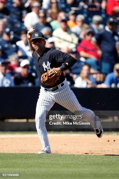 Danny Espinosa of the New York Yankees makes a running throw to first base during the third inning of the Spring Training game against the Tampa Bay...