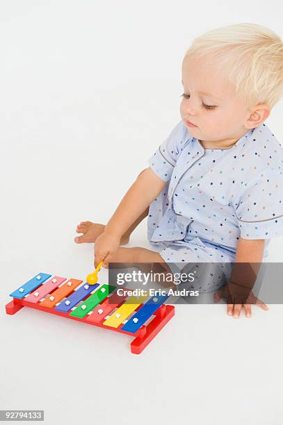 baby boy playing with a xylophone - xylophone stock-fotos und bilder