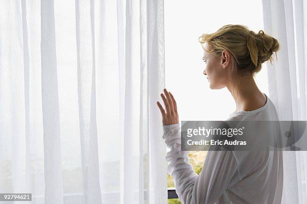 rear view of a woman standing on balcony - see thru nightgown - fotografias e filmes do acervo