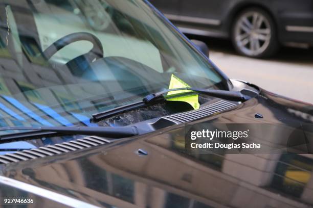 violation ticket for illegal parking on a vehicles windshield - parkvergehen-strafzettel stock-fotos und bilder