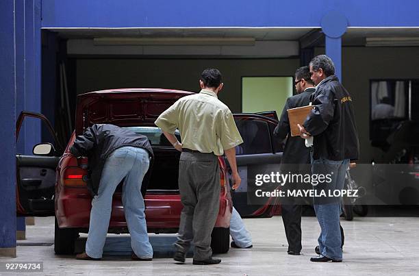 Members of Costa Rican Judicial Investigation Organisation check a car of the security company Avahuer on November 5 in San Jose during a raid as...