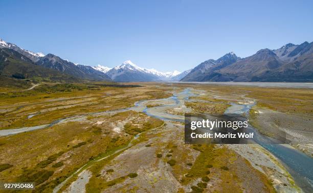 wide riverbed of tasman river, mount cook at back, mount cook national park, canterbury region, south island, new zealand - canterbury region new zealand stockfoto's en -beelden