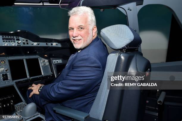 Quebec Premier Philippe Couillard poses for a photograph in an A380 flight simulator during a visit at the Airbus A380 aircraft assembly site in...