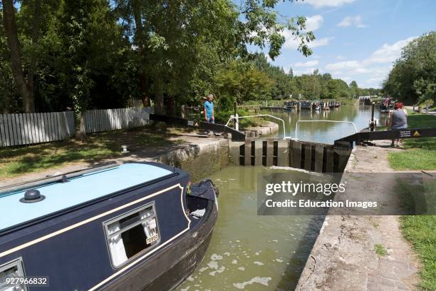Canal boat passing through a lock on the Caen Hill Flight of locks at Devizes Wiltshire, England UK.