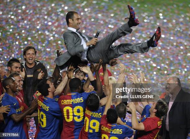 Barcelona players lift their coach Pep Guardiola in celebration of their Spanish league title 2009 after their Spanish League football match against...