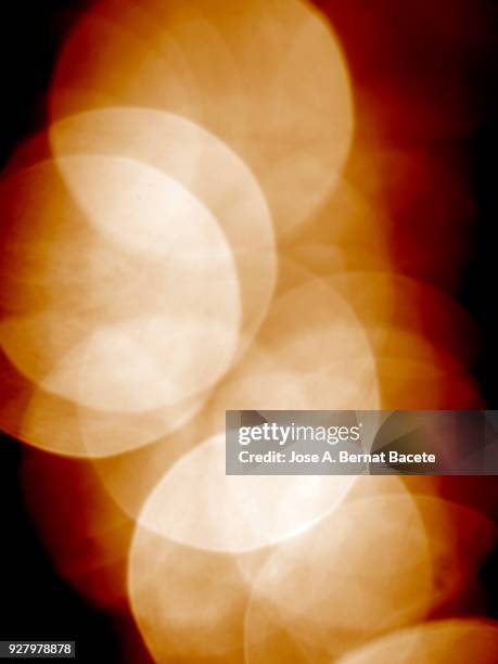 close-up unfocused lights in the shape of circles of colors outdoors, wallpaper of light yellow and orange colors. high resolution photography. - yellow light effect stock pictures, royalty-free photos & images