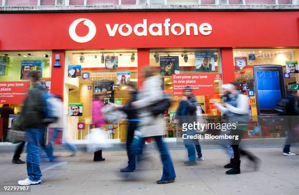 Pedestrians walk past a Vodafone store in London, U.K., on Wednesday, Nov. 4, 2009. U.K. Prosecutors are "looking into" allegations of possible fraud...