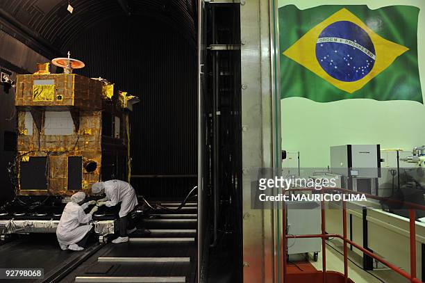 Brazilian researchers work inside a reinforced chamber on a CBERS satellite , a cooperative program between INPE , of Brazil, and CAST , of China, at...