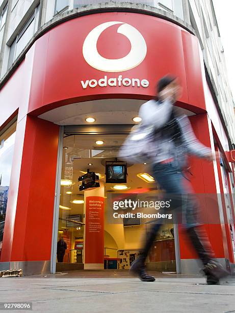 Pedestrian walks past a Vodafone store in London, U.K., on Wednesday, Nov. 4, 2009. U.K. Prosecutors are "looking into" allegations of possible fraud...
