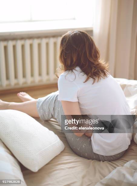 unhappy young women in the bedroom - pms stock pictures, royalty-free photos & images