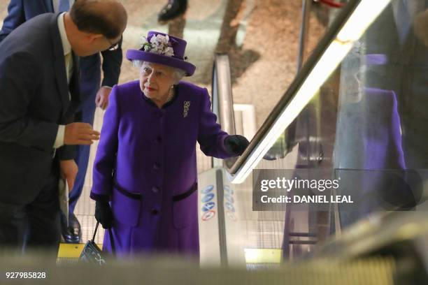 Britain's Queen Elizabeth II talks with Secretary-General of the International Maritime Organization Kitack Lim as she uses an escalator during a...