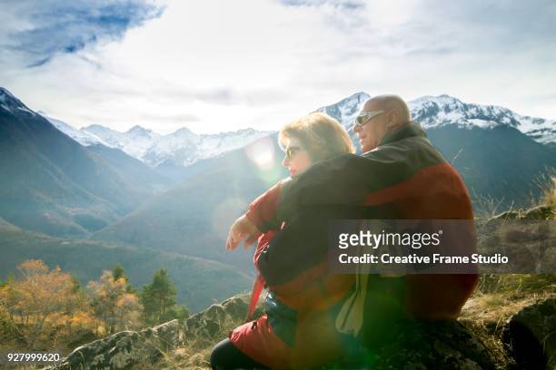 Senior couple contemplating and enjoying the view of the snowy summits
