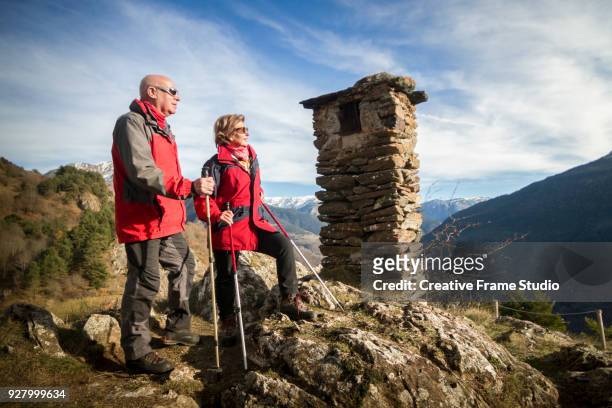 senior couple enjoying the view from the top of a summit - blank frame stockfoto's en -beelden