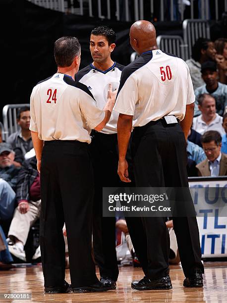 Mike Callahan, Zach Zarba and Olandis Poole converse during the game between the Atlanta Hawks and the Indiana Pacers at Philips Arena on October 28,...