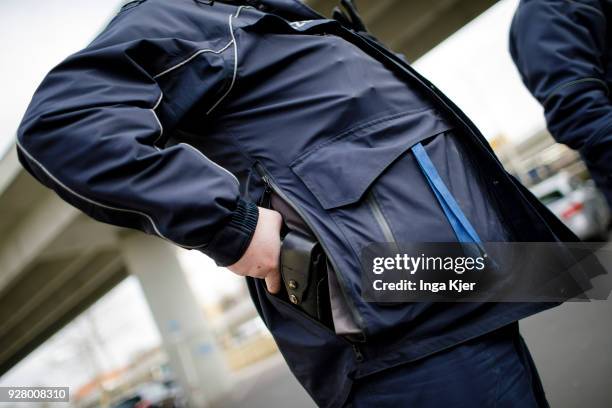 Police officer reaches for his service weapon on February 27, 2018 in Berlin, Germany.