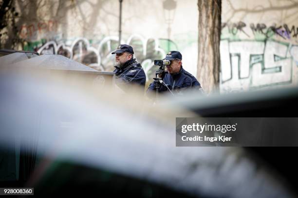 Two police officers measure the speed of road users with a speedometer on February 27, 2018 in Berlin, Germany.