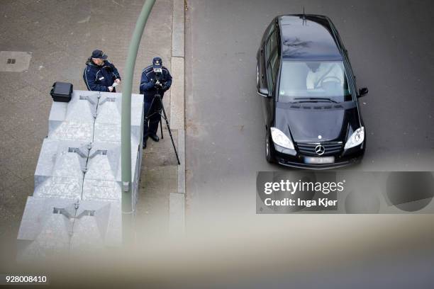 Two police officers measure the speed of road users with a speedometer on February 27, 2018 in Berlin, Germany.