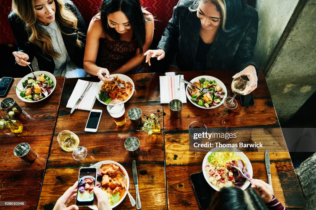 Overhead view of smiling female friends sharing lunch in restaurant