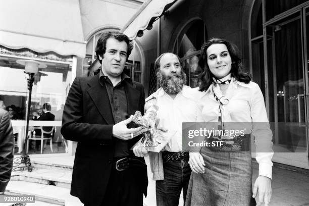 Italian Bernardo Bertolucci flanked by French sculptor Cesar and its millionth spectator , poses after being awarded the "Raoul Levy" prize for his...