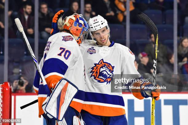 Parker Wotherspoon of the Bridgeport Sound Tigers congratulates goaltender Kristers Gudlevskis for their victory against the Laval Rocket during the...