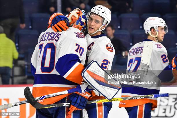 Ben Holmstrom of the Bridgeport Sound Tigers hugs goaltender Kristers Gudlevskis for their victory against the Laval Rocket during the AHL game at...