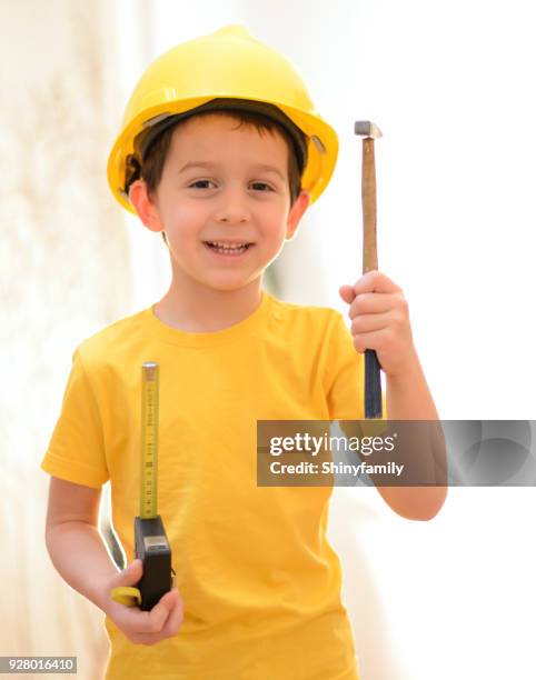 petit travailleur de la construction avec des outils à main et un casque - boy in hard hat photos et images de collection