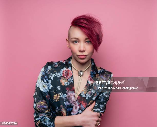 punk woman in colorful jacket on pink background