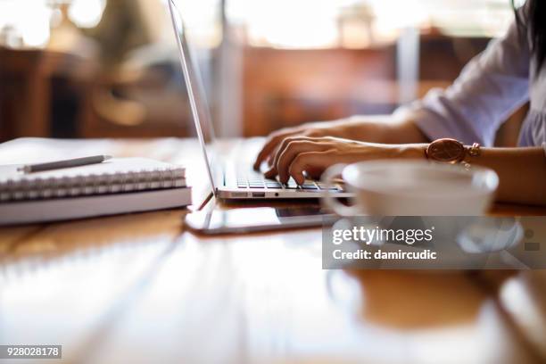 vrouw die op laptop in een café werkt - laptop work search stockfoto's en -beelden