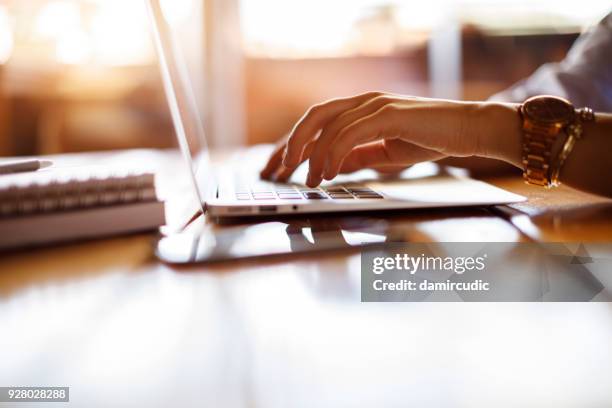 woman typing on laptop at a cafe - social networking and blogging website twitter stock pictures, royalty-free photos & images