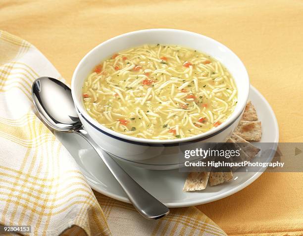 chicken noodle soup in cup with saucer and spoon and napkin - noodle soup stock pictures, royalty-free photos & images