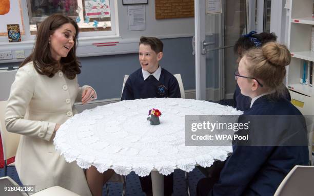 Catherine, Duchess of Cambridge speaks with with pupils Jodie, Zhara and Emilia during a visit to to learn about the work of the charity Family Links...