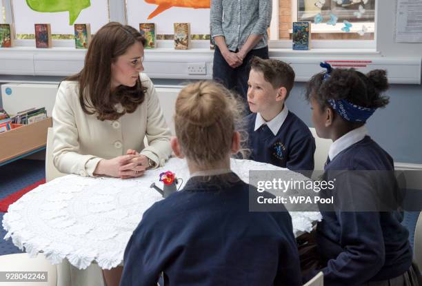 Catherine, Duchess of Cambridge speaks with with pupils Jodie, Zhara and Emilia during a visit to to learn about the work of the charity Family Links...