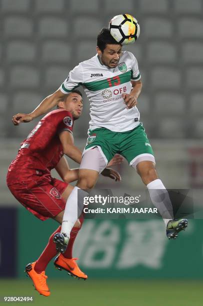 Al-Duhail Karim Boudiaf views for the ball with Lokomotiv's Sardor Mirzayev during the AFC Champions League football match between Lokomotiv of...