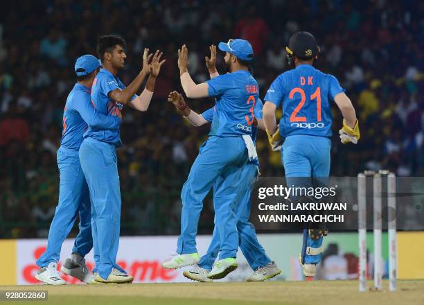 Indian cricketer Washington Sundar celebrates with his teammates after he dismissed Sri Lankan cricketer Kusal Mendis during the opening Twenty20...