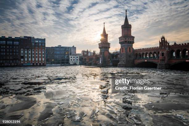 Ice floes are pictured on the river Spree during the sunset behind the bridge 'Oberbaumbruecke' on March 05, 2018 in Berlin, Germany.