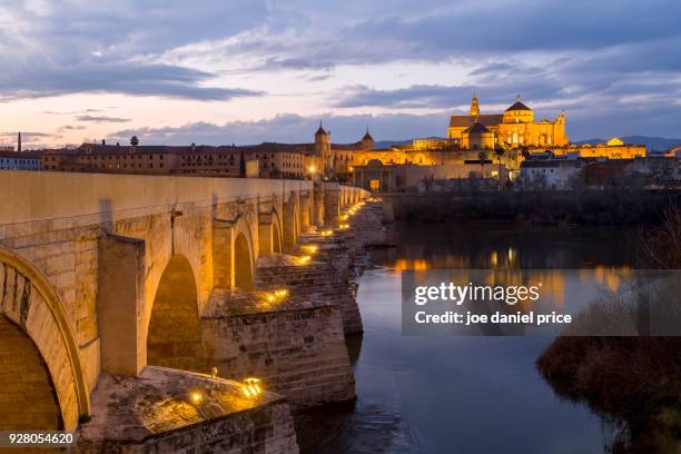 sunset at the cathedral of cordoba, puente romano, cordoba, spain - puente romano stock pictures, royalty-free photos & images