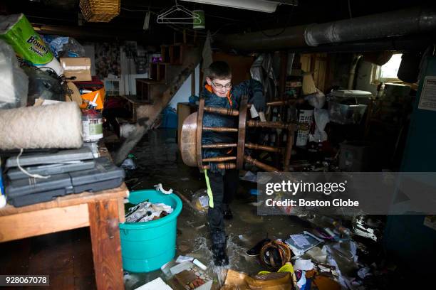 Walter Bardon removes flood damage items from the basement of his family's home in Quincy, MA in the aftermath of a nor'easter storm on March 5, 2018.