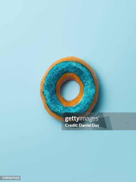 blue glitter donut against blue background - iced donuts stock pictures, royalty-free photos & images